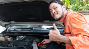 Car maintenance checklist car repairs man in orange shirt charging car battery